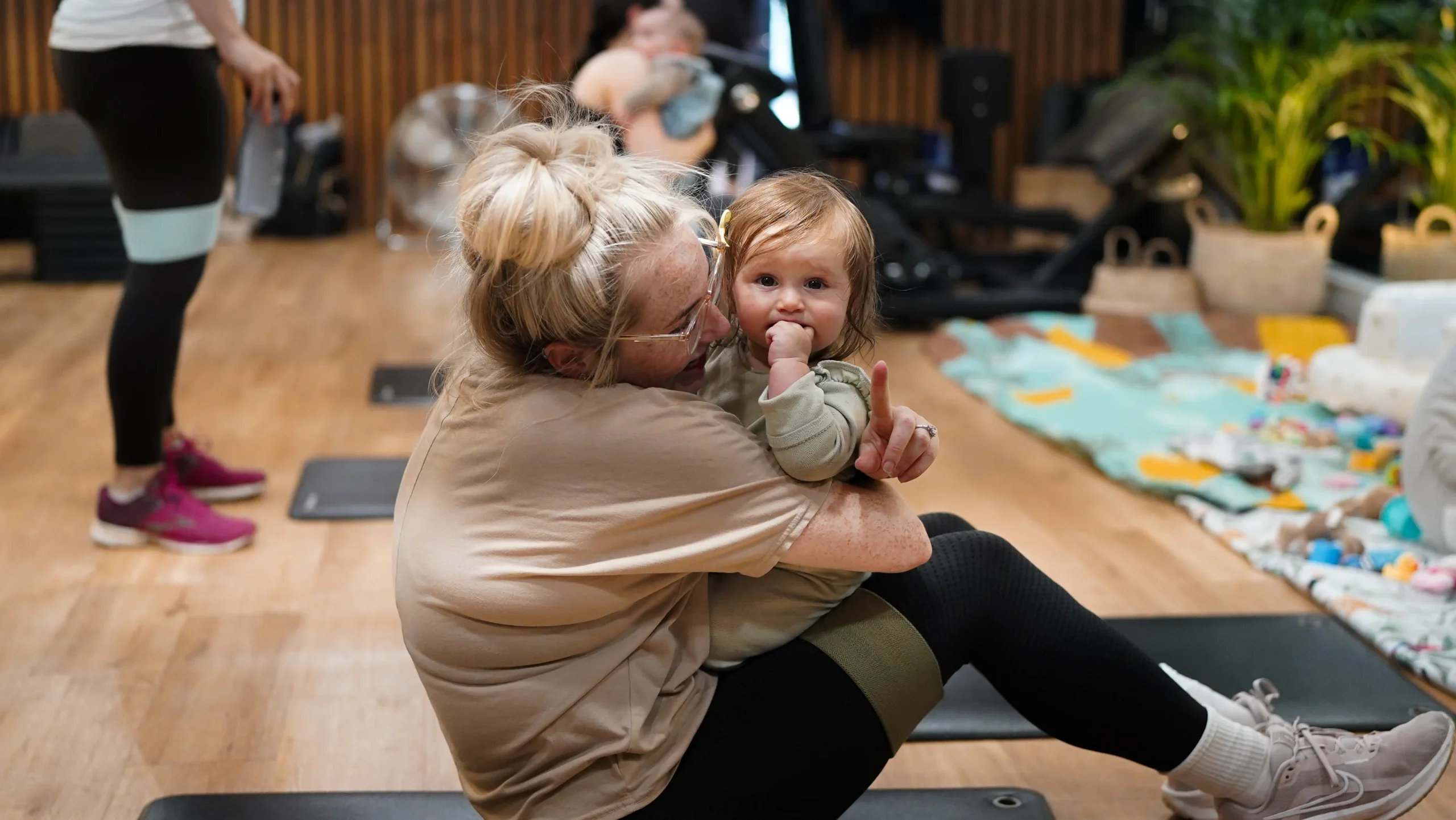Her Fitness member with Her Baby on gym mat