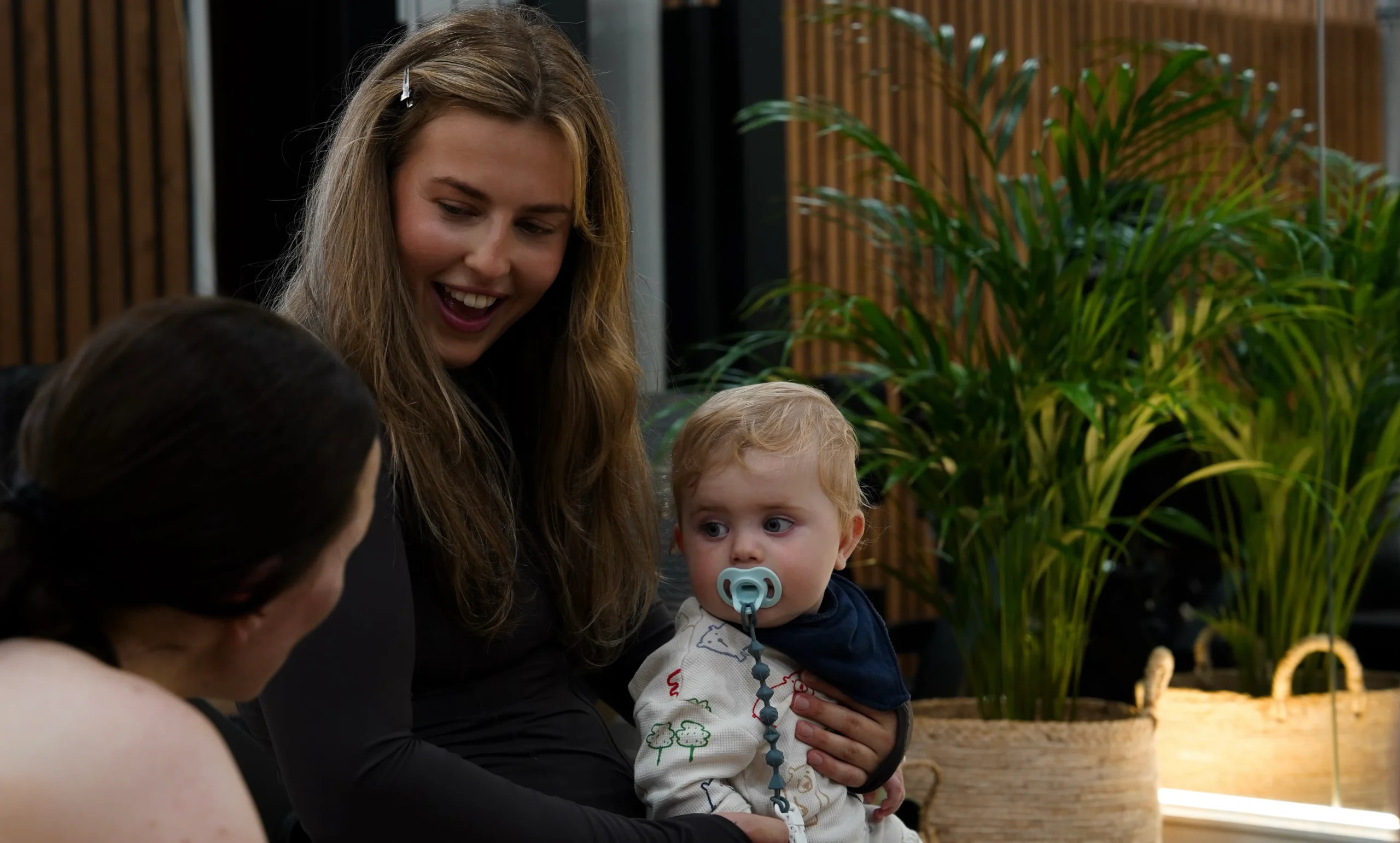 Her Fitness training smiling while holding a baby